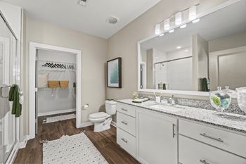 A bathroom with a white toilet, sink, and a mirror.